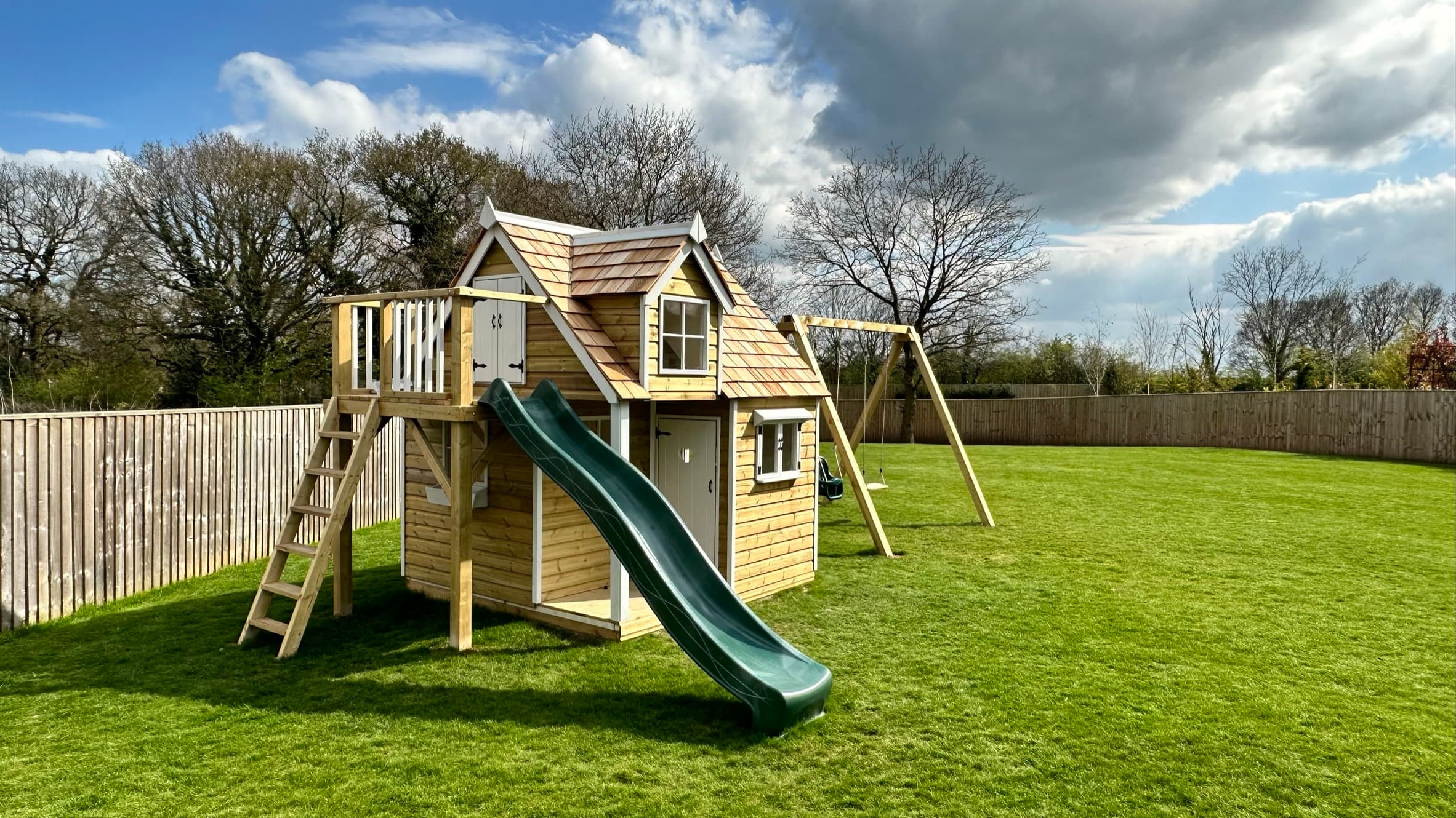 Badger Lodge designer playhouse, a natural-timber garden house set against an open sky