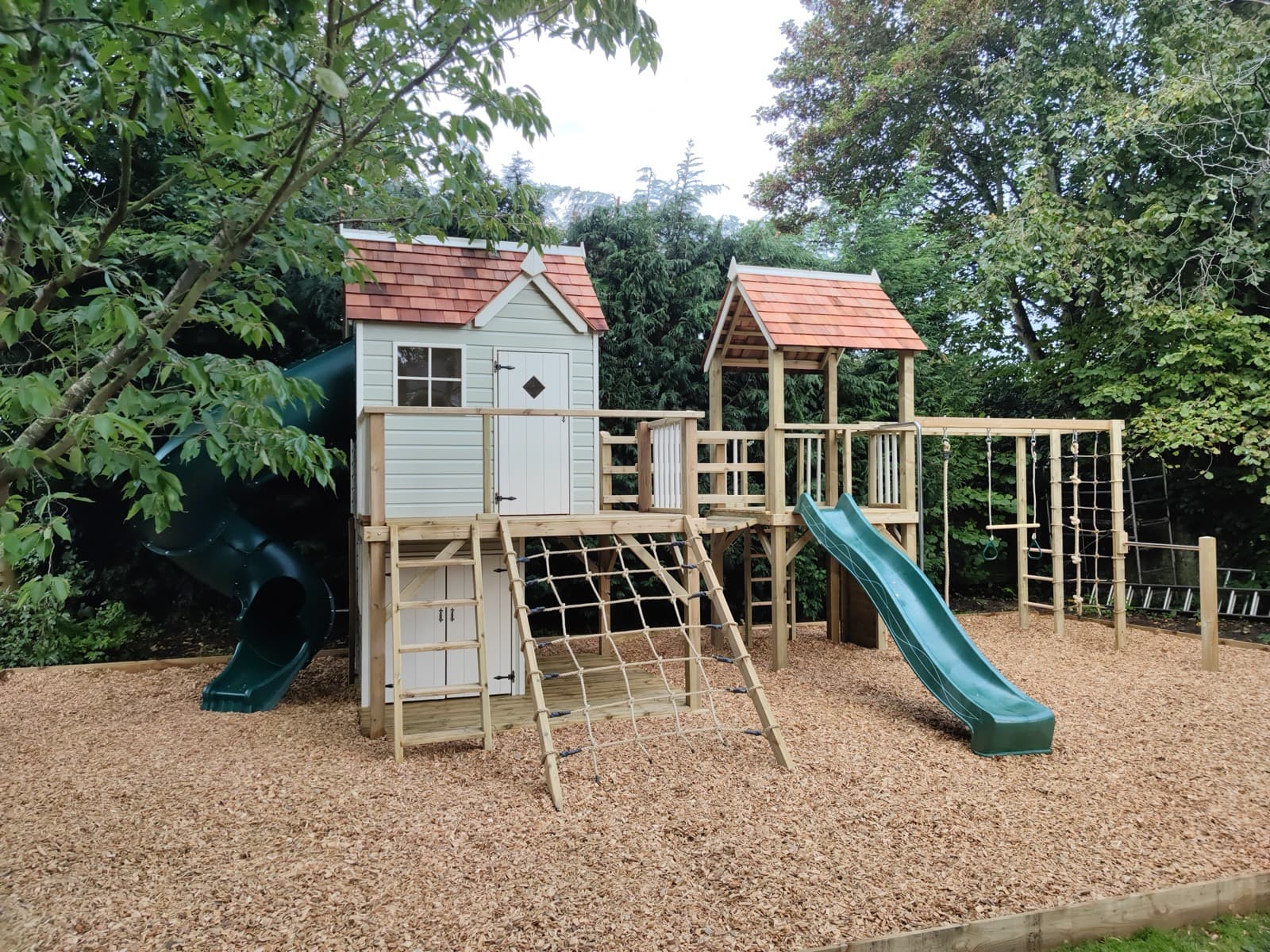 A Damson Mega Combo: the Damson cottage and lower den joined by a clatter bridge to a second play tower, with a wave slide and scramble nets