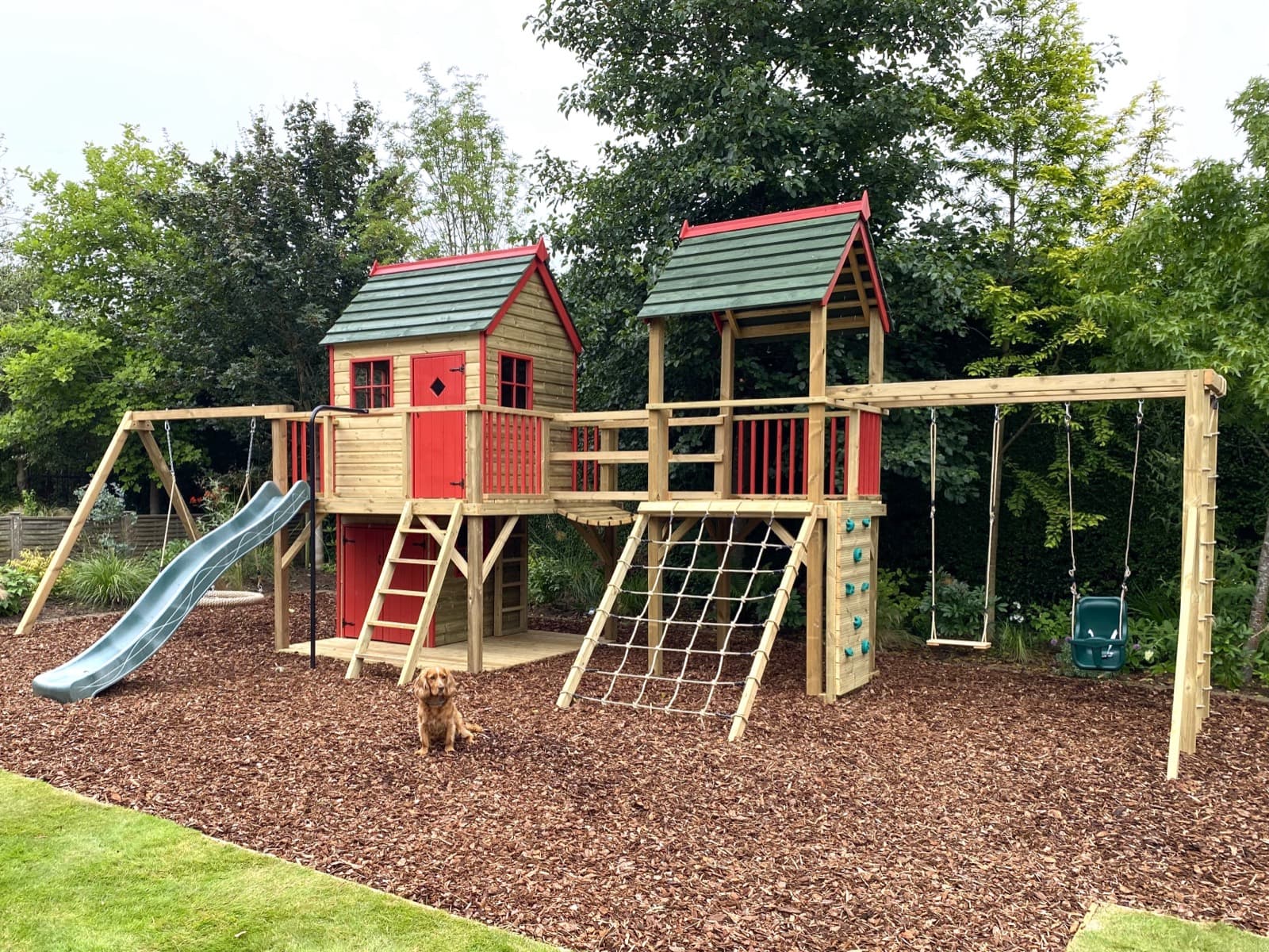 A Forest Mega Combo: the Forest Playhouse and lower den joined by a clatter bridge to a second play tower with a sloping scramble net