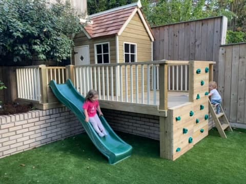 A Bespoke playhouse viewed through garden planting