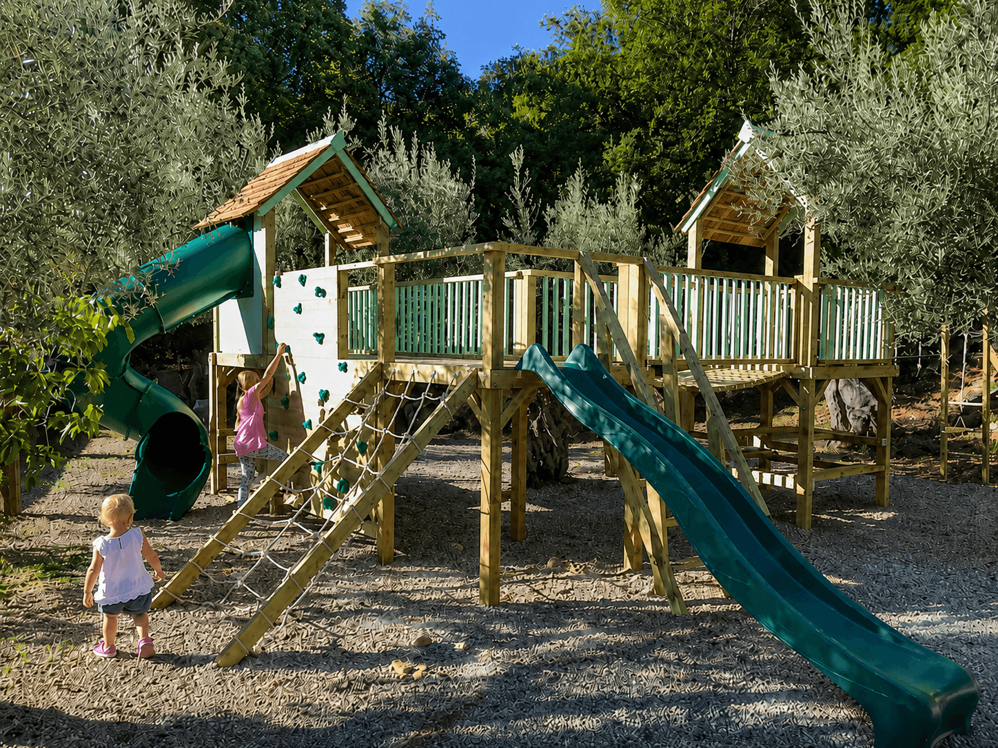 The Treetops Wonderland in Hampshire: twin cedar-roofed towers among the trees, with tube slide, wave slide, and scramble nets