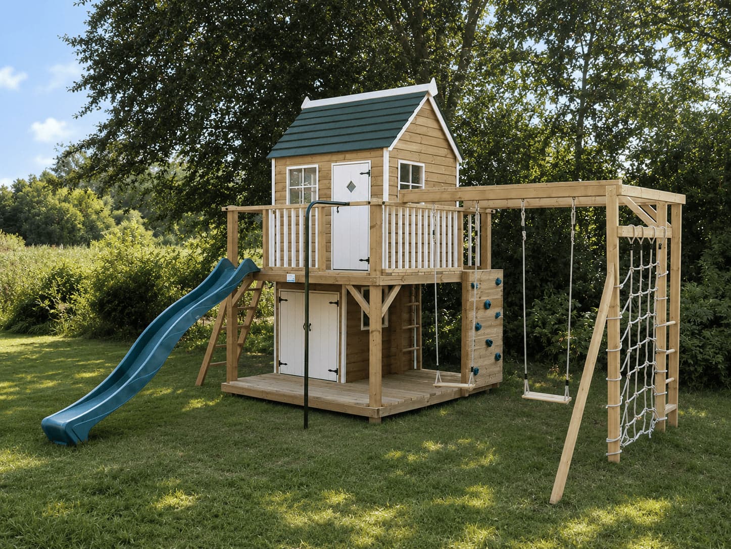 A raised timber playhouse with a green shingled roof and white balcony, a blue wave slide, swings, climbing wall and rope scramble net