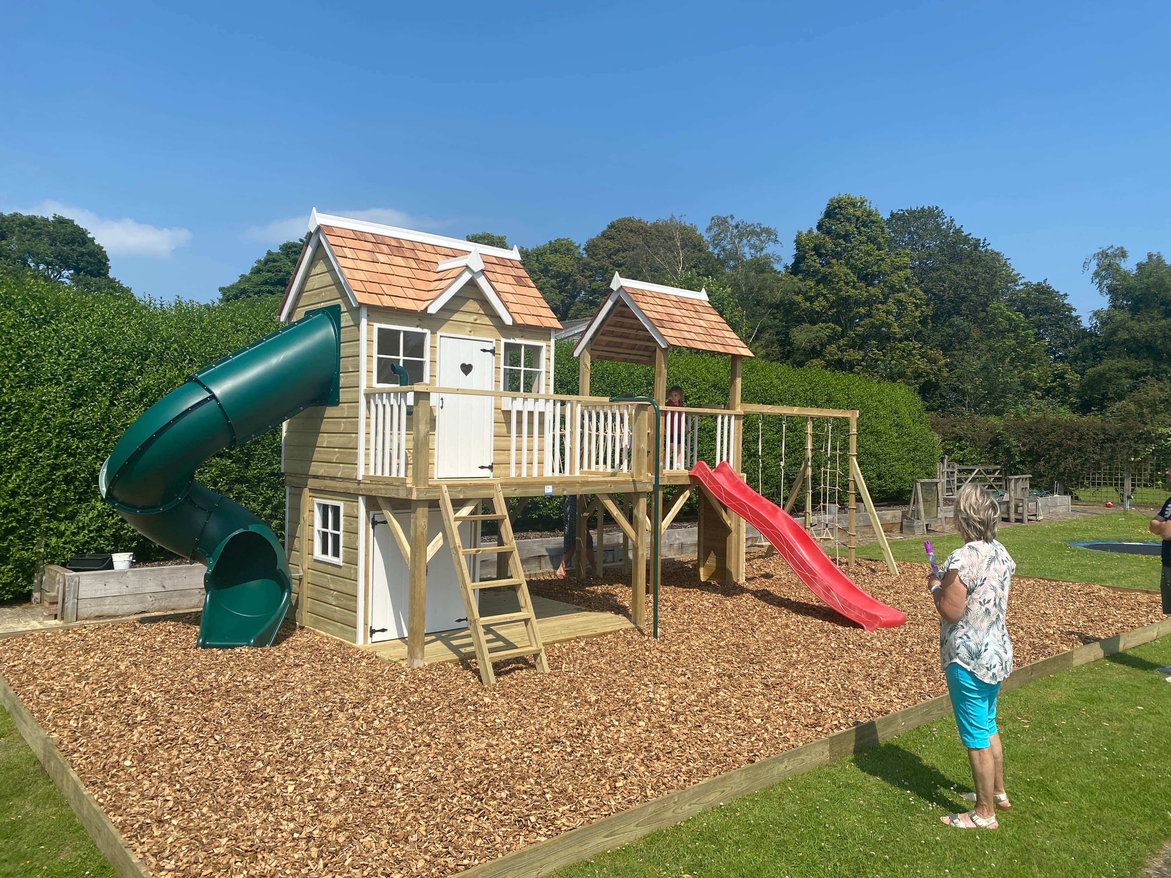 Children playing on a Bespoke Garden Play structure in a beautiful UK garden