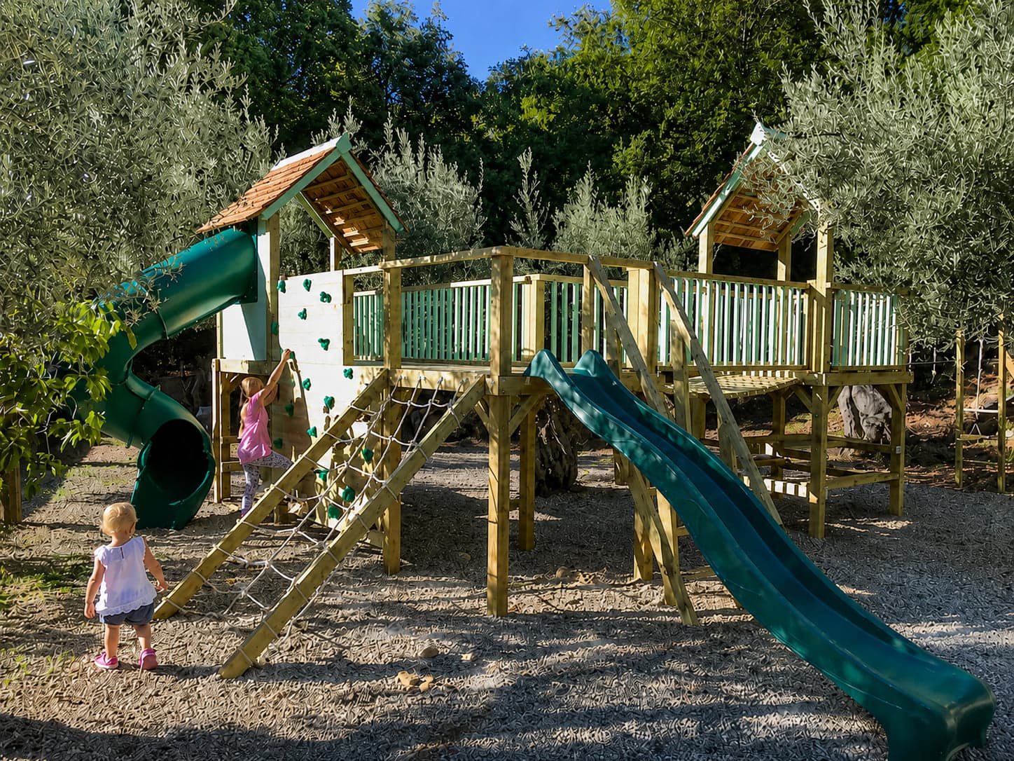 The Treetops Wonderland in Hampshire: twin cedar-roofed towers among the trees, with tube slide, wave slide, and scramble nets